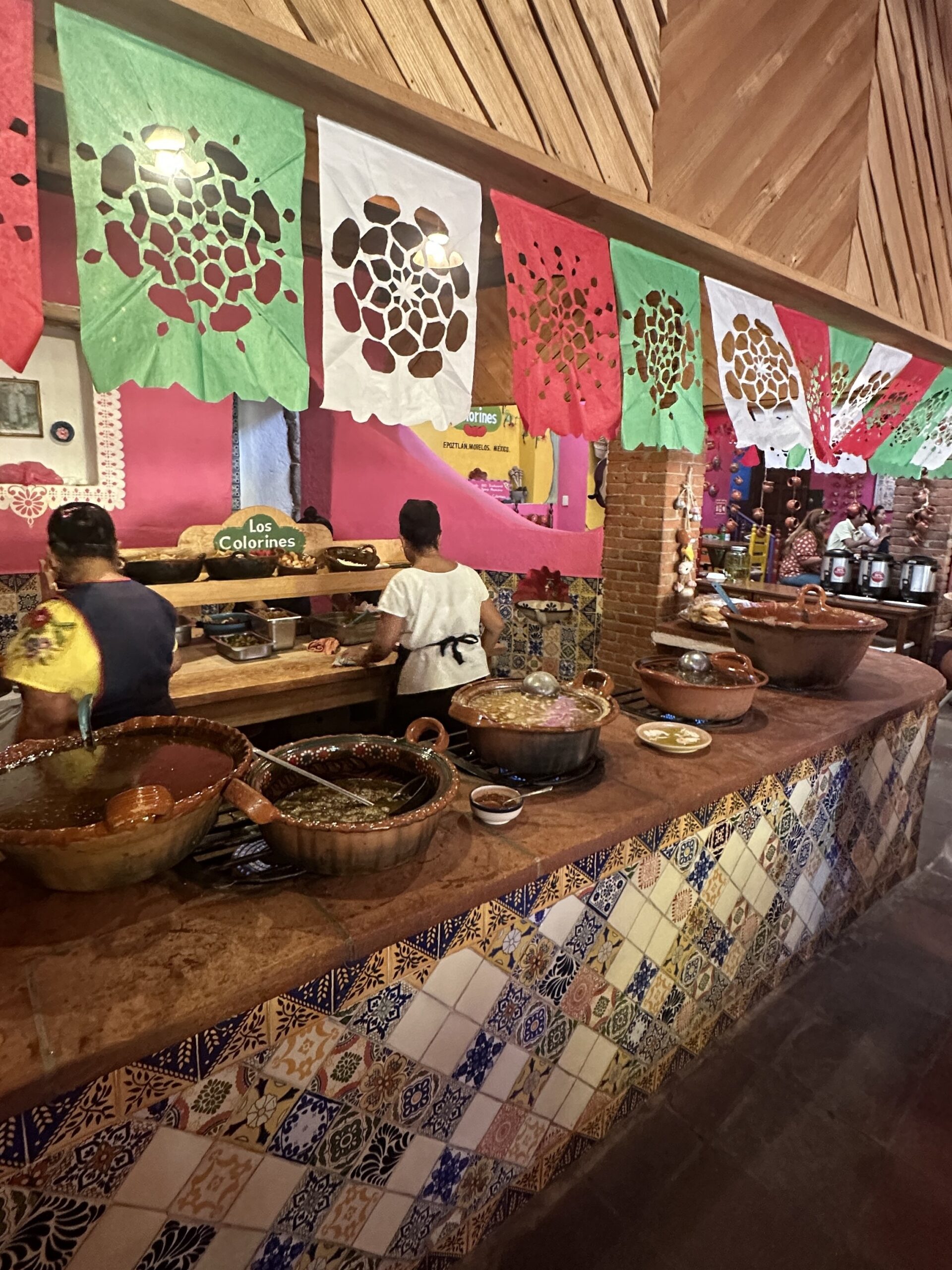 A vibrant buffet of authentic Mexican stews in clay pots at Los Colorines restaurant, a highlight of Tepoztlan tours.