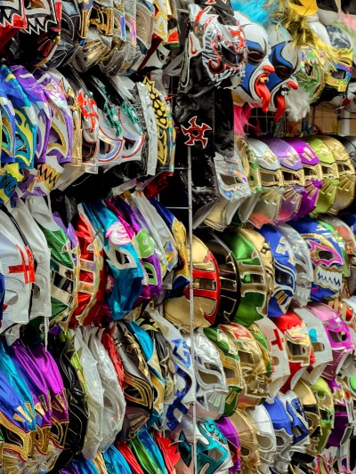 Colorful Mexican wrestling masks on display for fans wondering how much does it cost to get to the fights and gear up.
