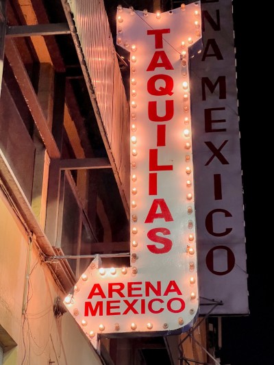 A vintage neon Taquillas sign for those checking how much does it cost to get to the fights at the Arena Mexico box office.