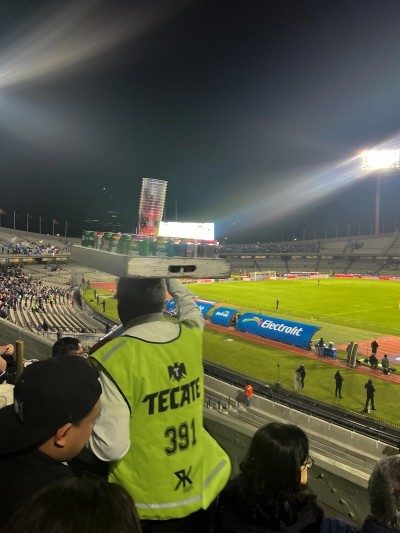 A traditional stadium vendor carrying drinks on his head, a unique sight at the World Cup 2026 Mexico stadiums.