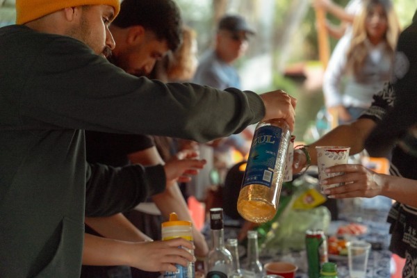 Pouring drinks for a party on the water, part of the cultural things to do in Xochimilco with friends.
