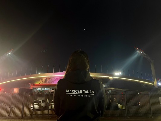 A traveler overlooking the illuminated exterior architecture of the historic World Cup 2026 Mexico stadiums at night.