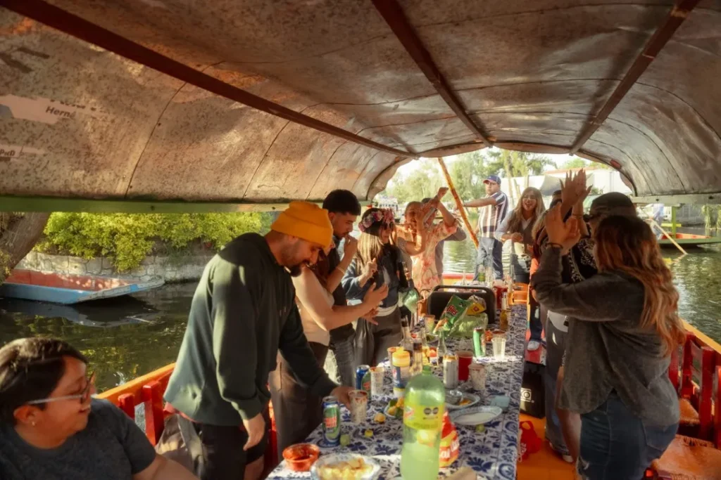 Friends enjoying music, drinks, and food inside a boat party, from The ultimate Xochimilco guide for tourists.