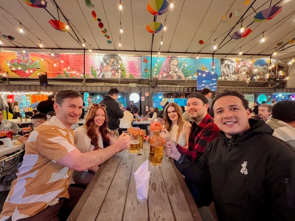 Is Mexico City safe for tourists in 2026? Happy travelers toast with micheladas at a lively local restaurant.