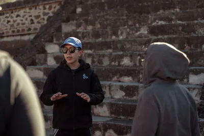 Tour guide giving an explanation next to ancient pre-Hispanic steps in the Tepoztlán vs Teotihuacan travel debate.
