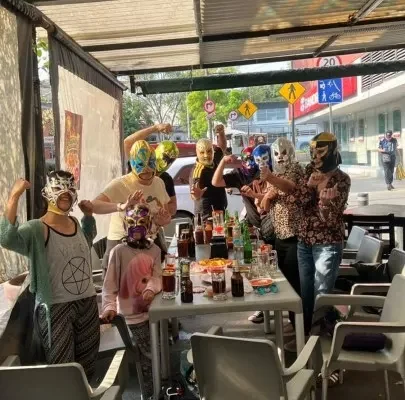 Is Mexico City safe for tourists in 2026? Group of travelers wearing colorful Lucha Libre masks at a terrace.
